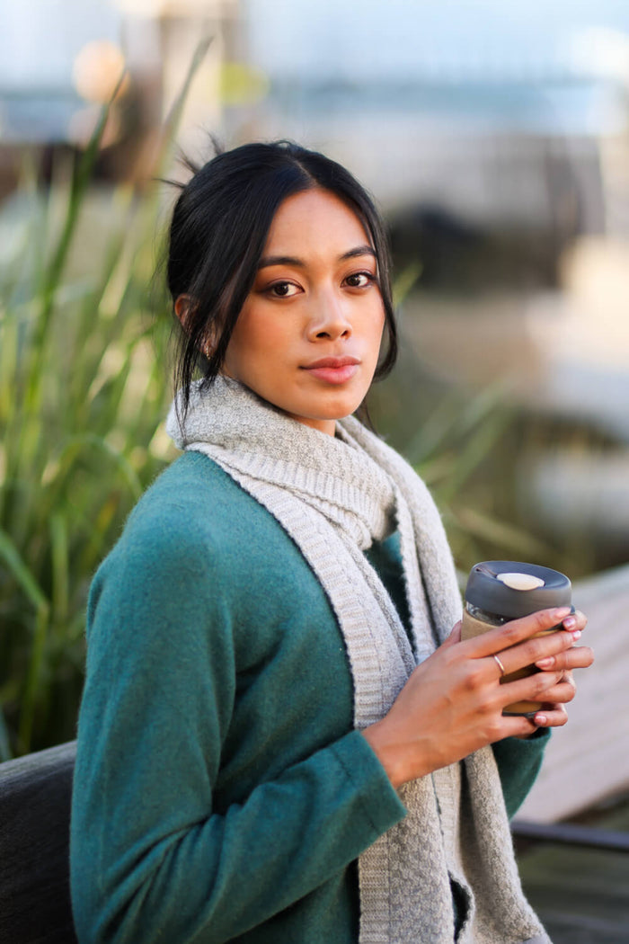 Woman holding a coffee cup outdoors with blurred background