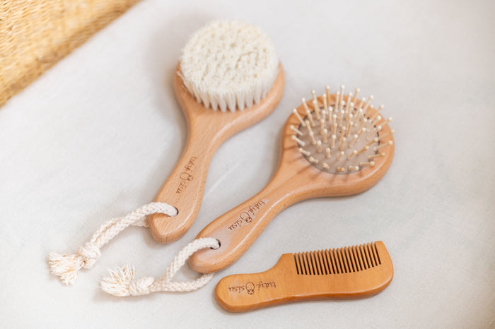 Set of wooden hairbrushes and a comb on a light background