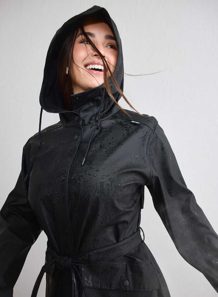 Hymyilevä nainen yllään märkä musta aim'n Rain Jacket huppu päässä [M-174cm]