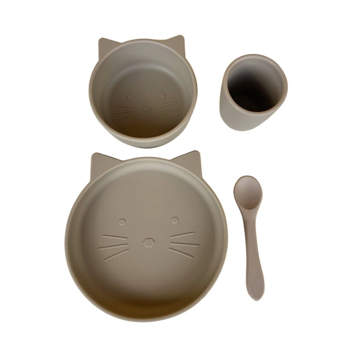 A four-piece baby and toddler dinnerware set featuring a cat design, including a suction plate, suction bowl, spoon, and cup in a sand color.