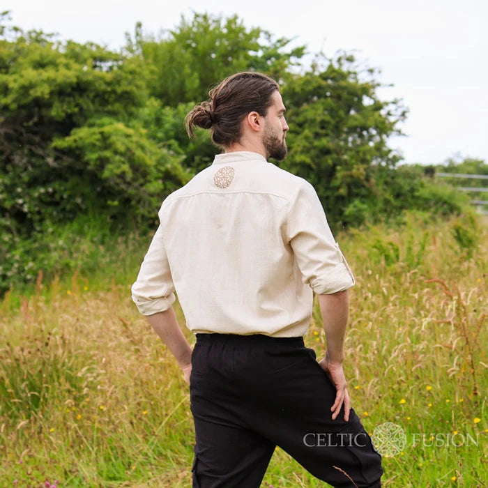 Celtic collarless dress shirt for men in white natural cotton slub, styled outdoors as part of Irish Celtic Clothing outfit with a relaxed formal look