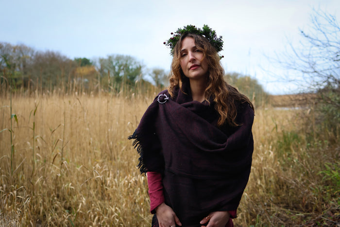 Woman wearing a silver plated Celtic shawl brooch with dark handwoven wrap in an Irish landscape