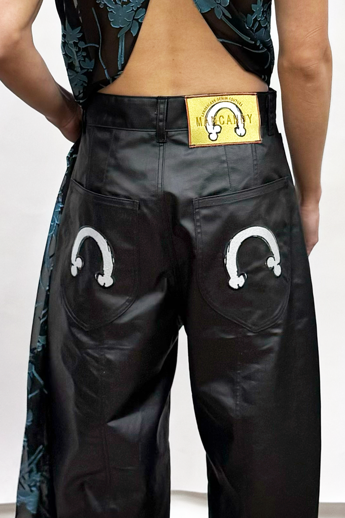 MANCANDY Coated Biker Baggy Jeans in black coated denim featuring articulated panel construction, knee pocket detail and embroidered back pockets.