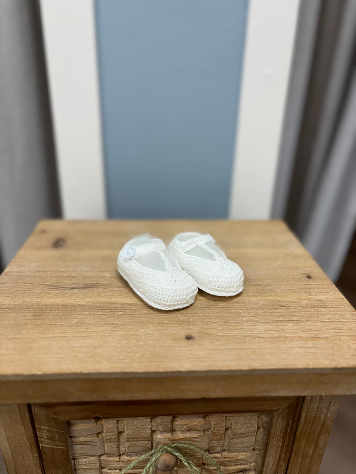 Crochet baby bootie with flower button.