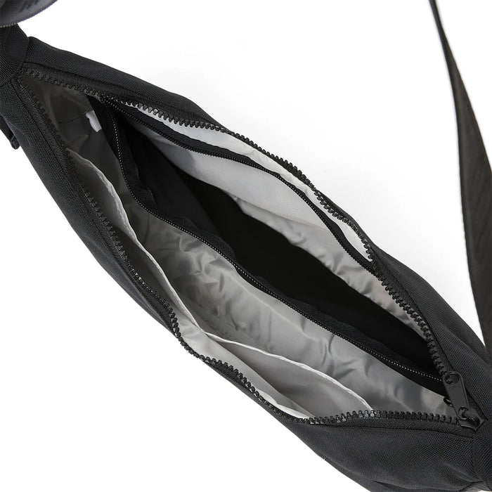 Ela Mo™ Moon Bag | Schwarz. Innenbereich der Umhängetasche mit kleinem Fach und Reißverschluss innen.