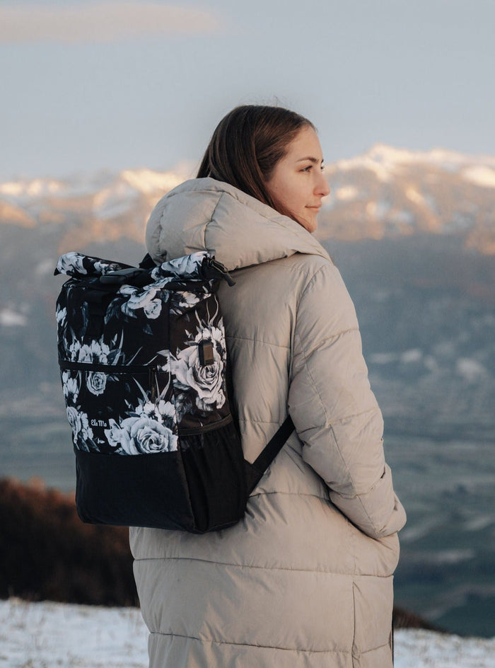 Ela Mo™ Rolltop Rucksack | Nightrose.  Eine Frau mit dem Rucksack auf dem Rücken im Freien.