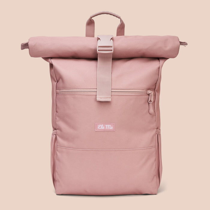 Ela Mo™ Rolltop Rucksack | Pastel Rose. Ein Rucksack auf rosa Hintergrund mit Herstellerlogo in der Mitte