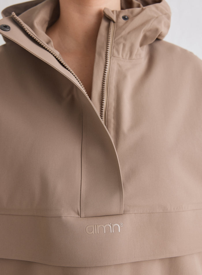 Lähikuva aim'n-logosta ja vetoketjusta espresso-värisessä Waterproof Oversized Anorak -anorakissa [M-174cm]