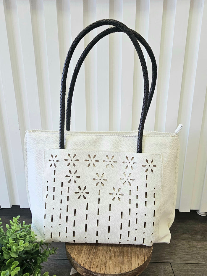 Leather tote bag with floral detail.