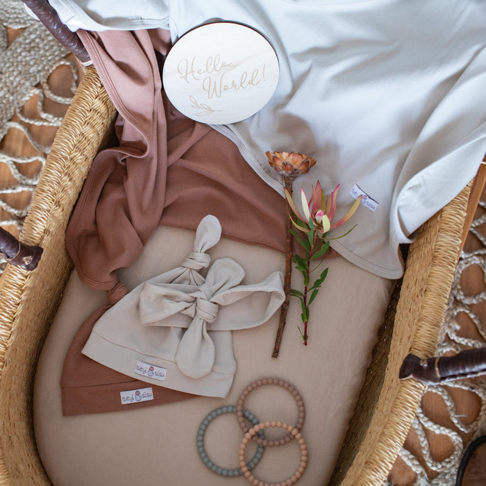 Organic cotton swaddle with jersey wraps with matching beanie. Baby announcement milestone card 'hello world'.