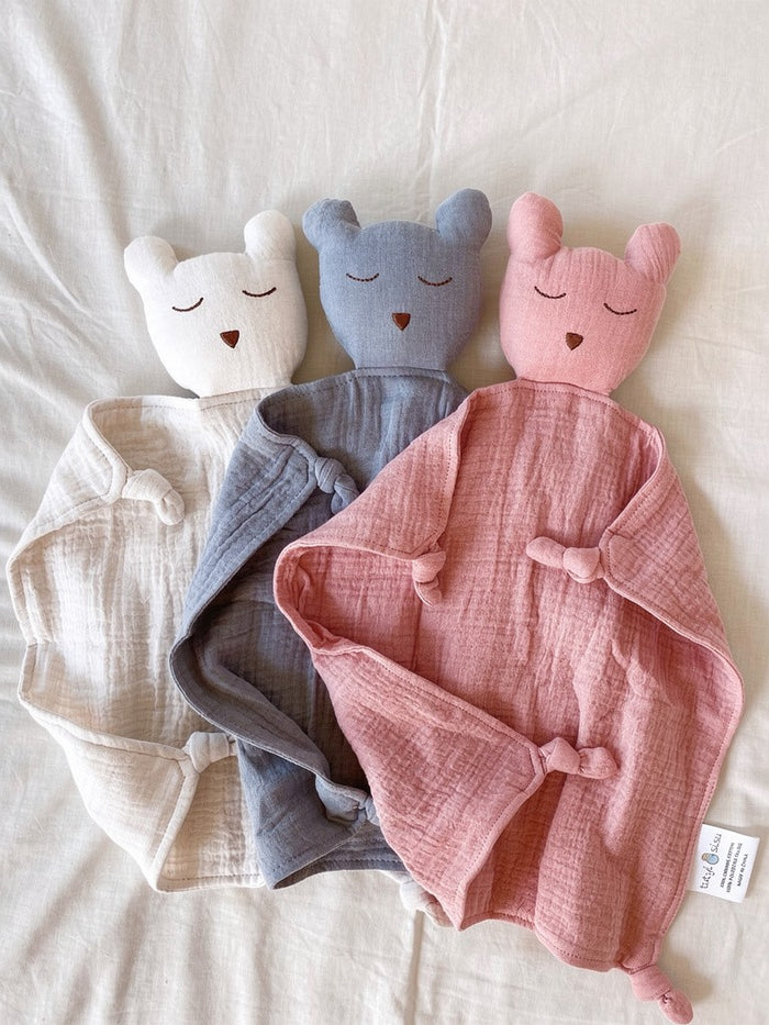 Three organic, soft, bear muslin baby comforters on a light background