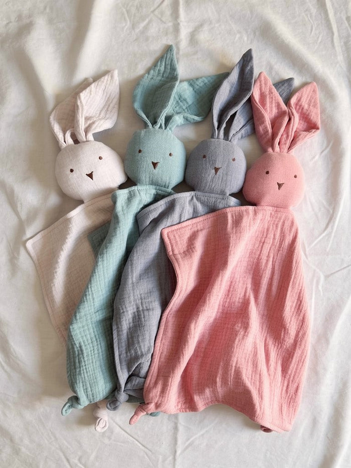 Four soft organic muslin bunny comforters in different colors on a light background