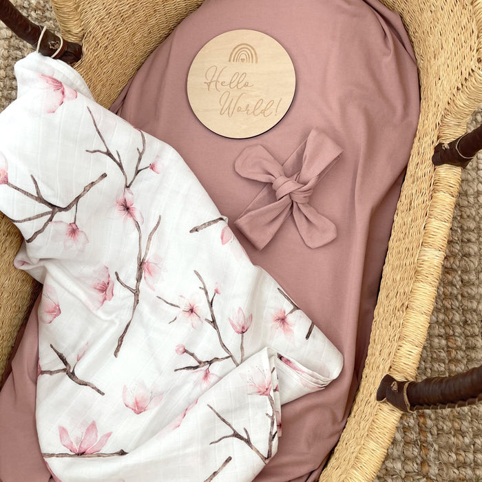 Birth announcement milestone card 'hello world' with headband and organic muslin swaddle.