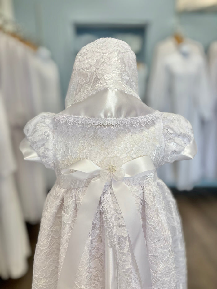 Long white lace and satin baby gown with bow and bonnet.