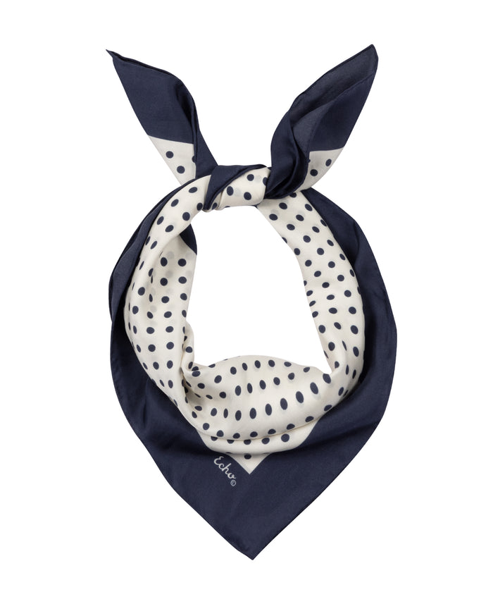 Navy blue and white polka dot scarf on a white background