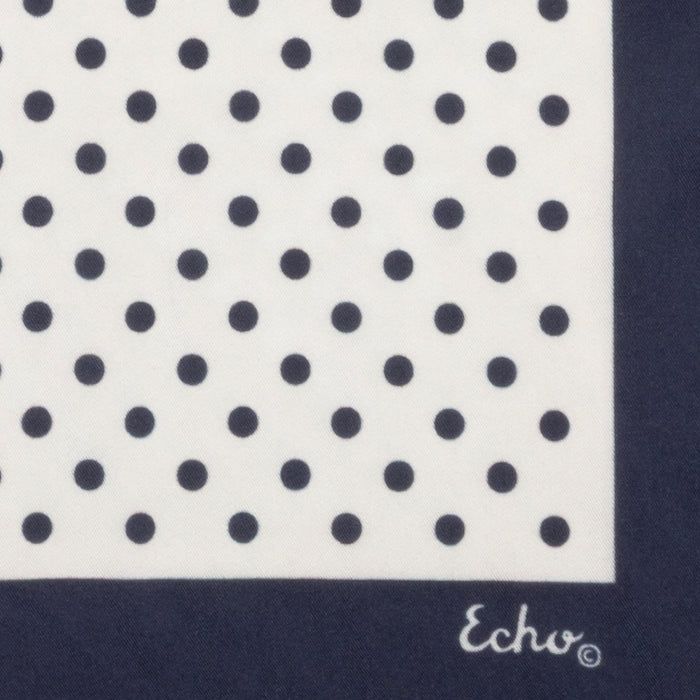 Navy blue square scarf with white polka dot pattern on a white background