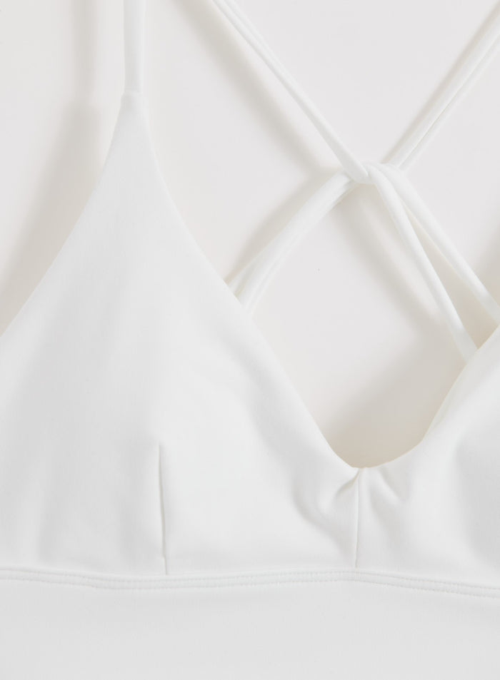 Valkoinen aim'n Sense Strap Bra, jossa on V-pääntie ja koristeelliset kapeat selkäremmit.