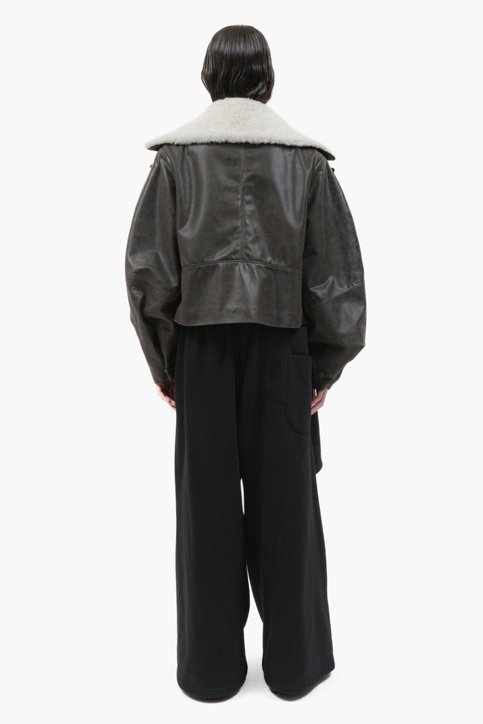 MANCANDY Wide Aviator Jacket in crackled black leather featuring a detachable shearling collar, oversized fit and curved sleeves.